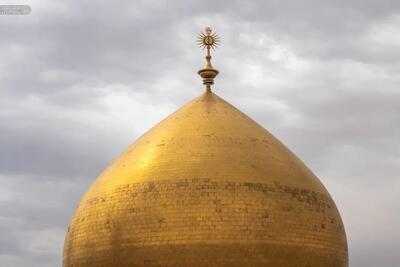 درخشش گنبد طلایی حرم امام علی(ع) در آسمان ابری نجف