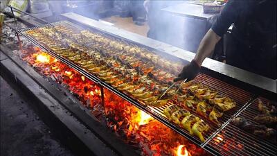طرز تهیه مرغ کبابی و یک غذای محلی با نارگیل و برنج در بامبو (فیلم)