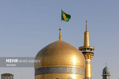 آیین تعویض پرچم گنبد مطهر در روز ولادت امام رضا(ع)