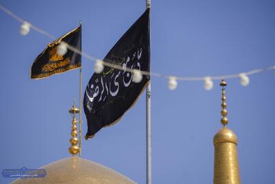عکس/ تعویض پرچم گنبد مطهر امام هشتم علیه السلام